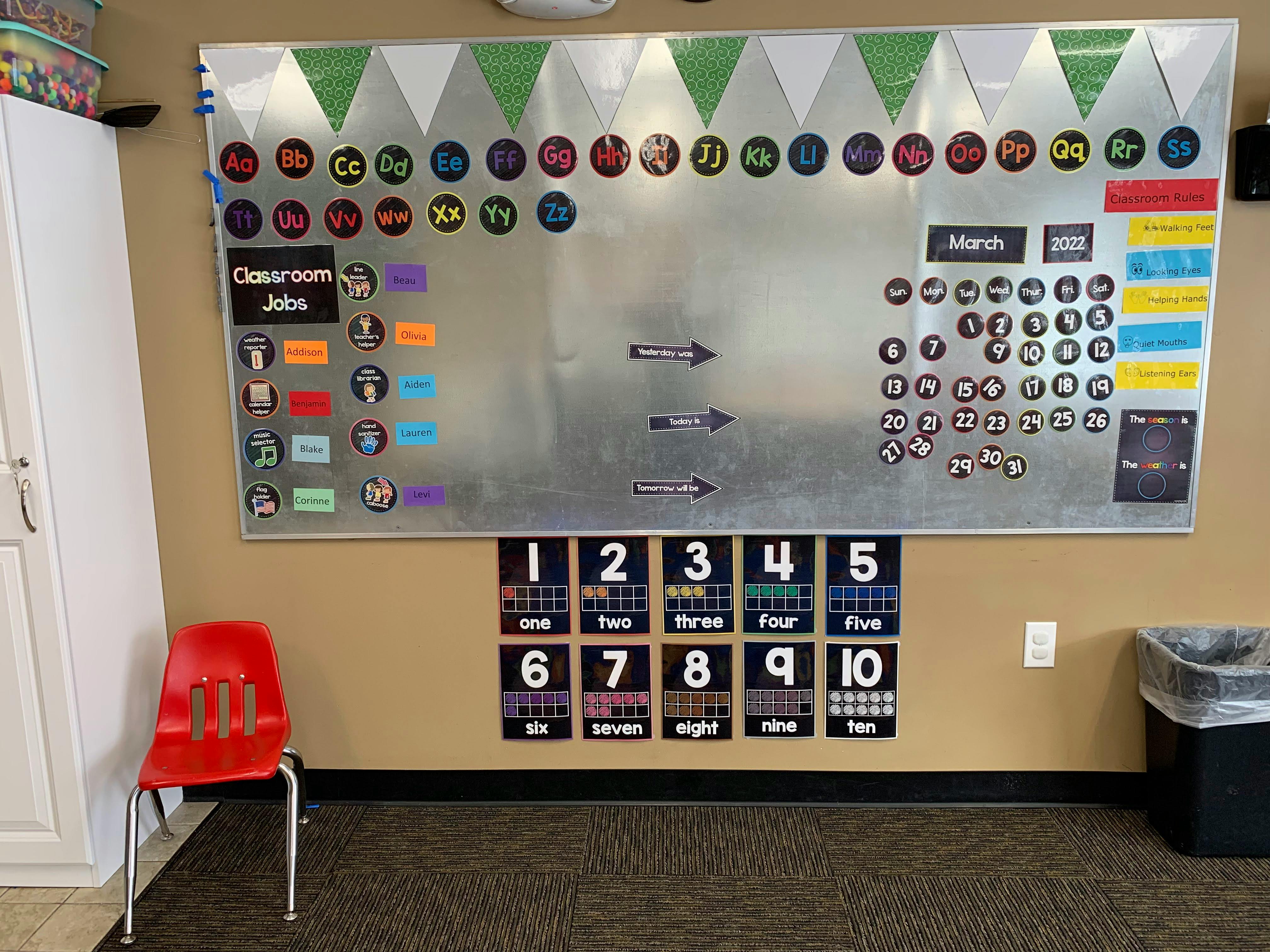 Classroom wall with a large magnetic board and number charts