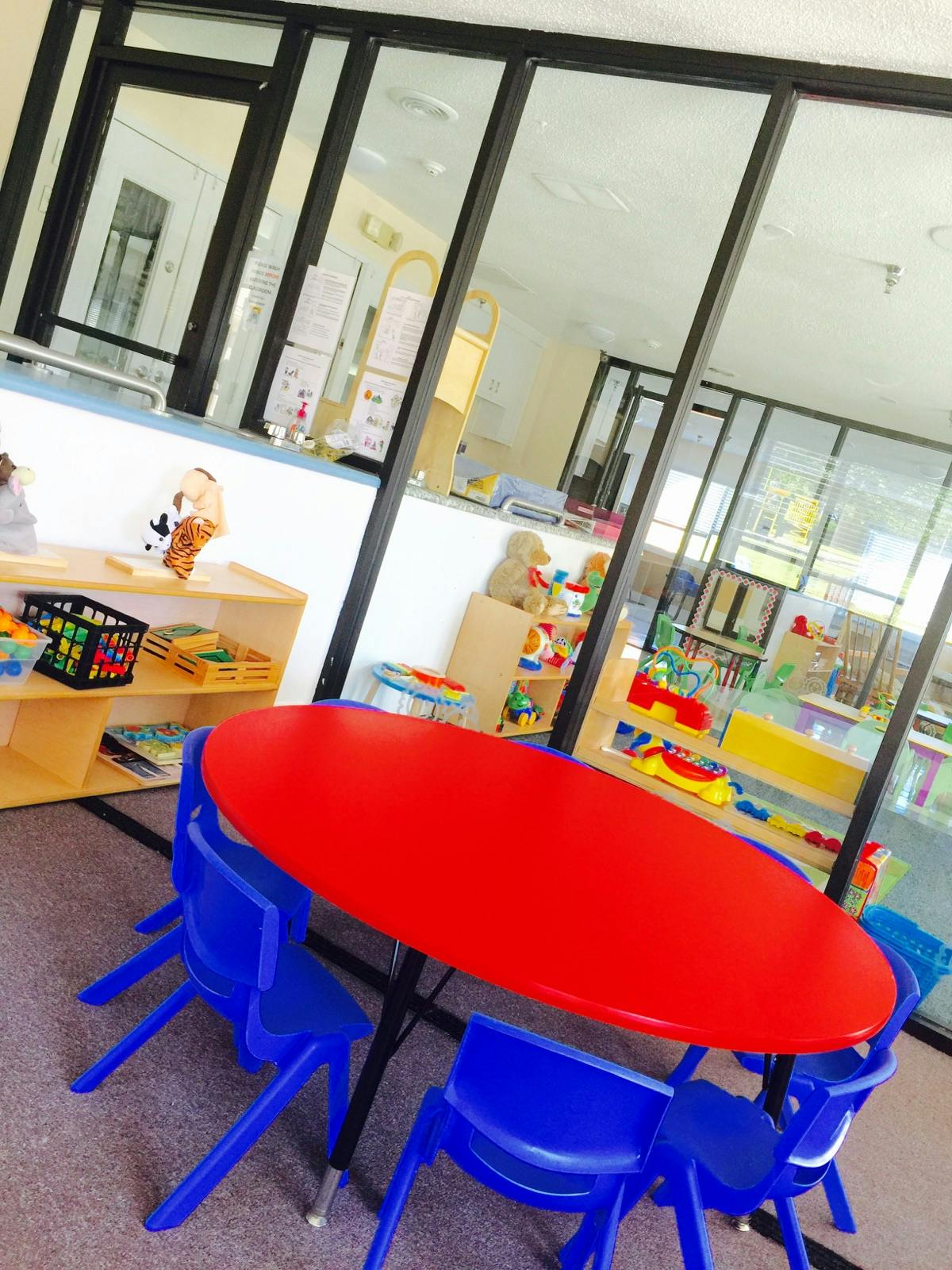 Red oval table with blue chairs in a classroom