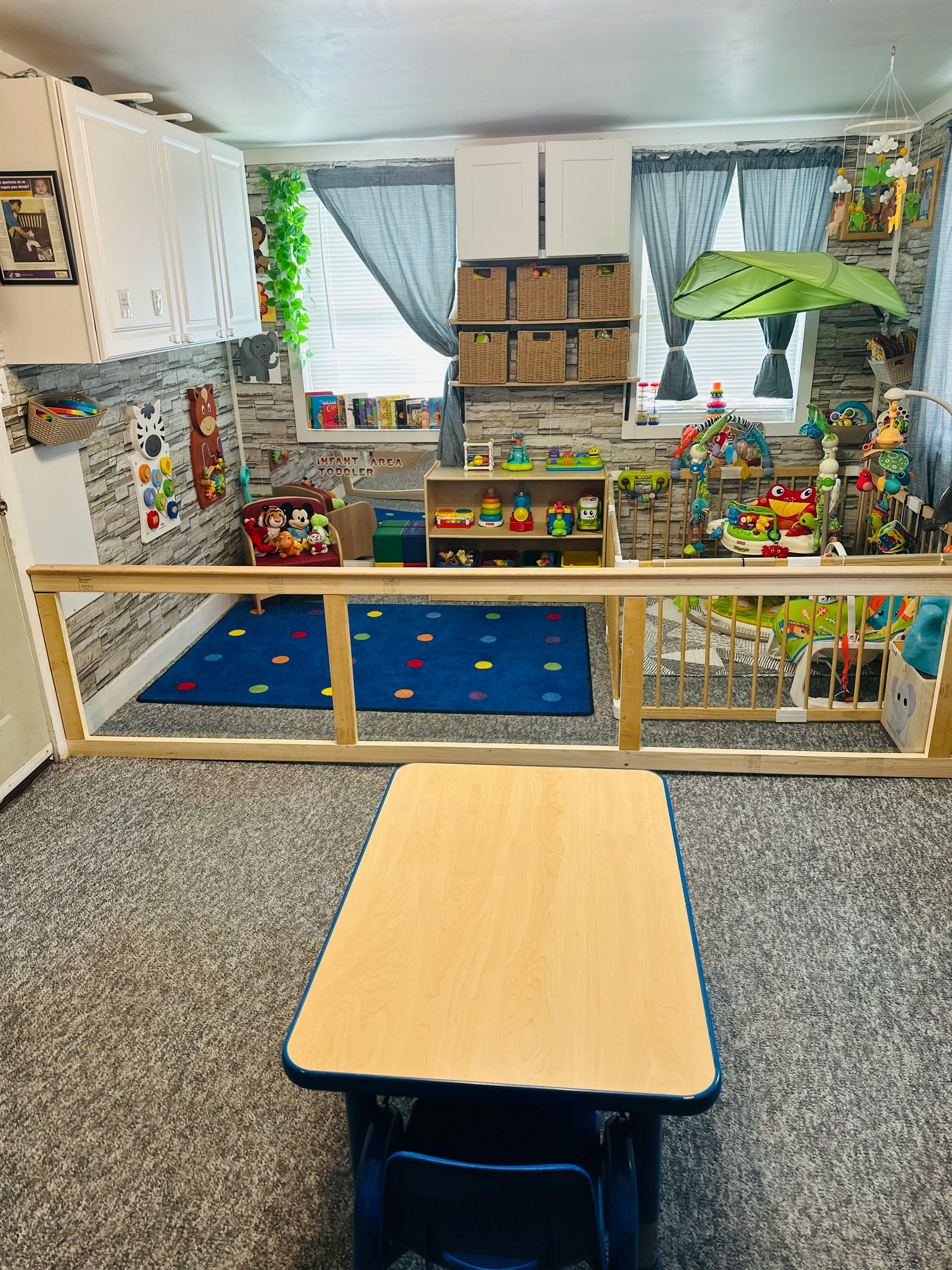 Playroom with a wooden gate separating a carpeted area from a play mat area