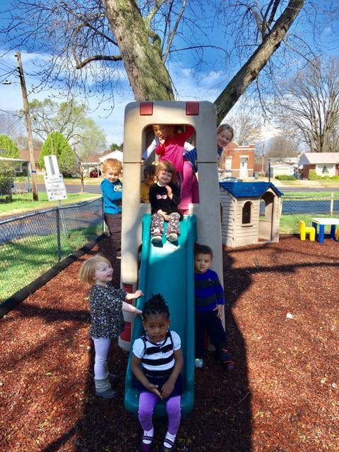 Children playing on a slide and play structure on a playground