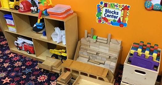 Playroom with toy shelf, wooden blocks, and a "Blocks Center" sign