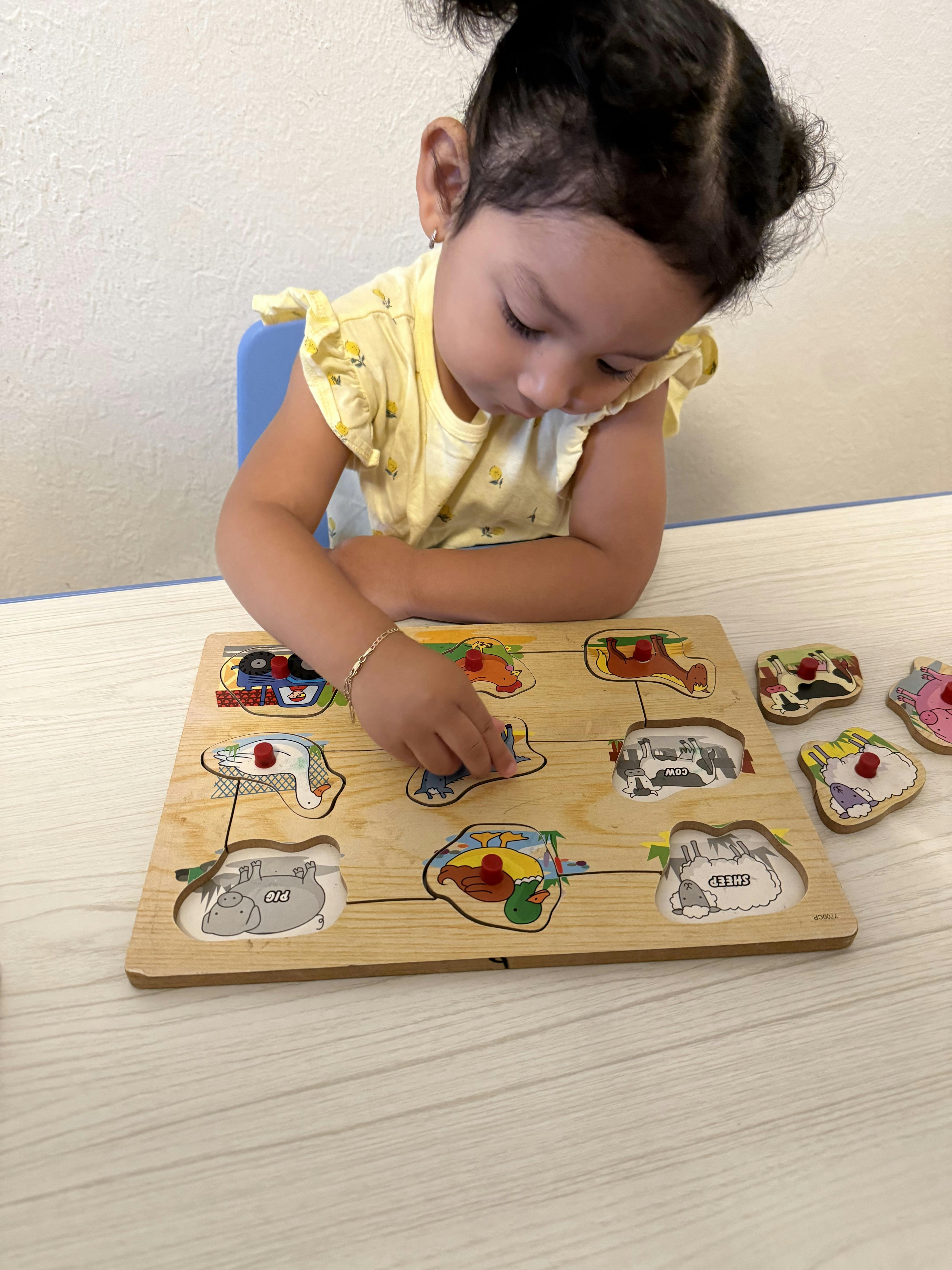 Child playing with a wooden animal puzzle