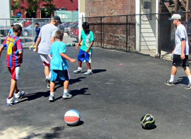Adult and children playing with balls outdoors