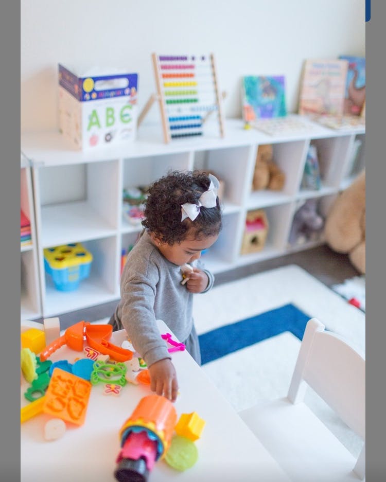 Child playing with colorful toys on a table