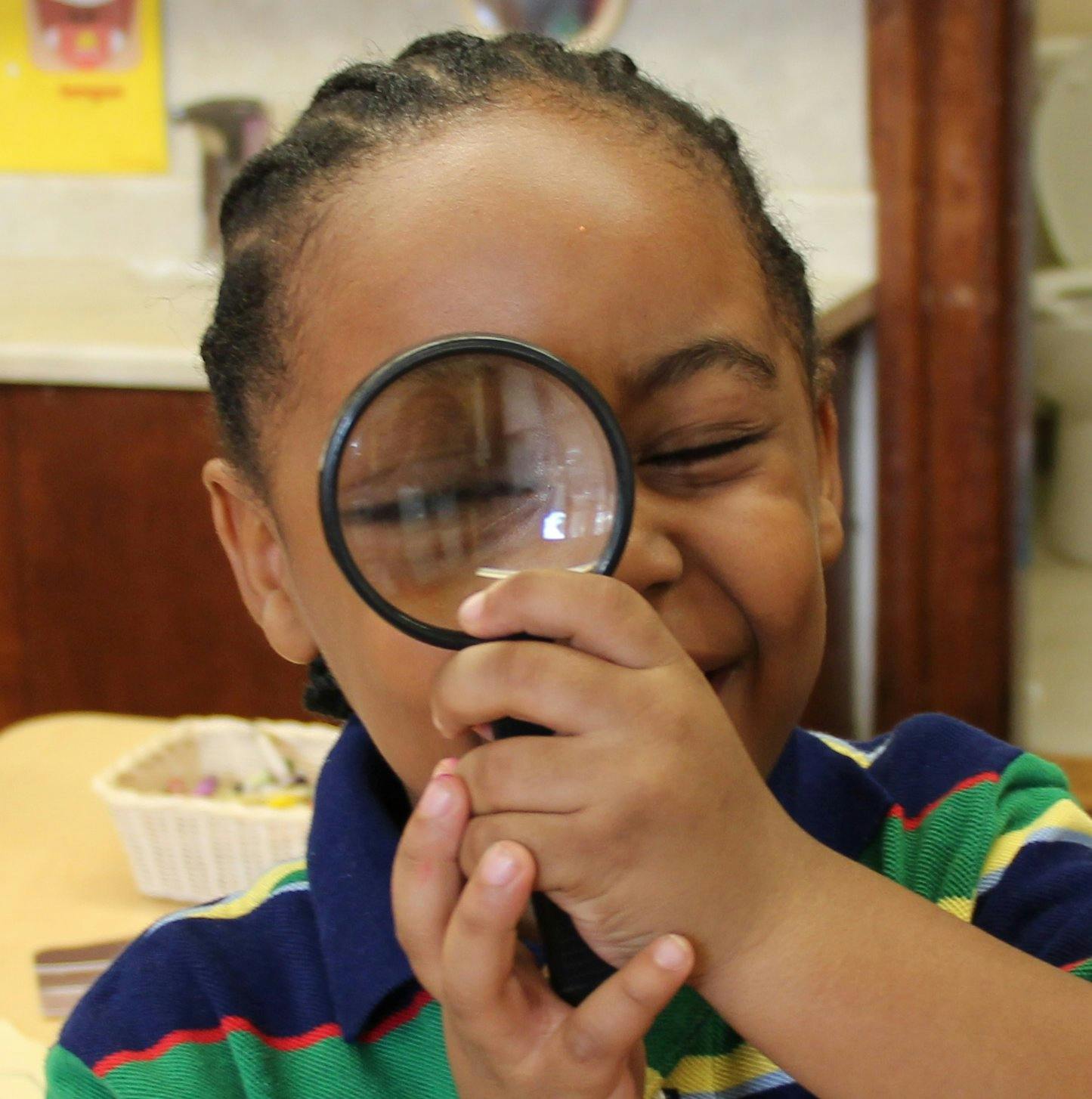 Child looking through a magnifying glass