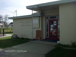 Exterior of a building with a red door and a sign on the wall