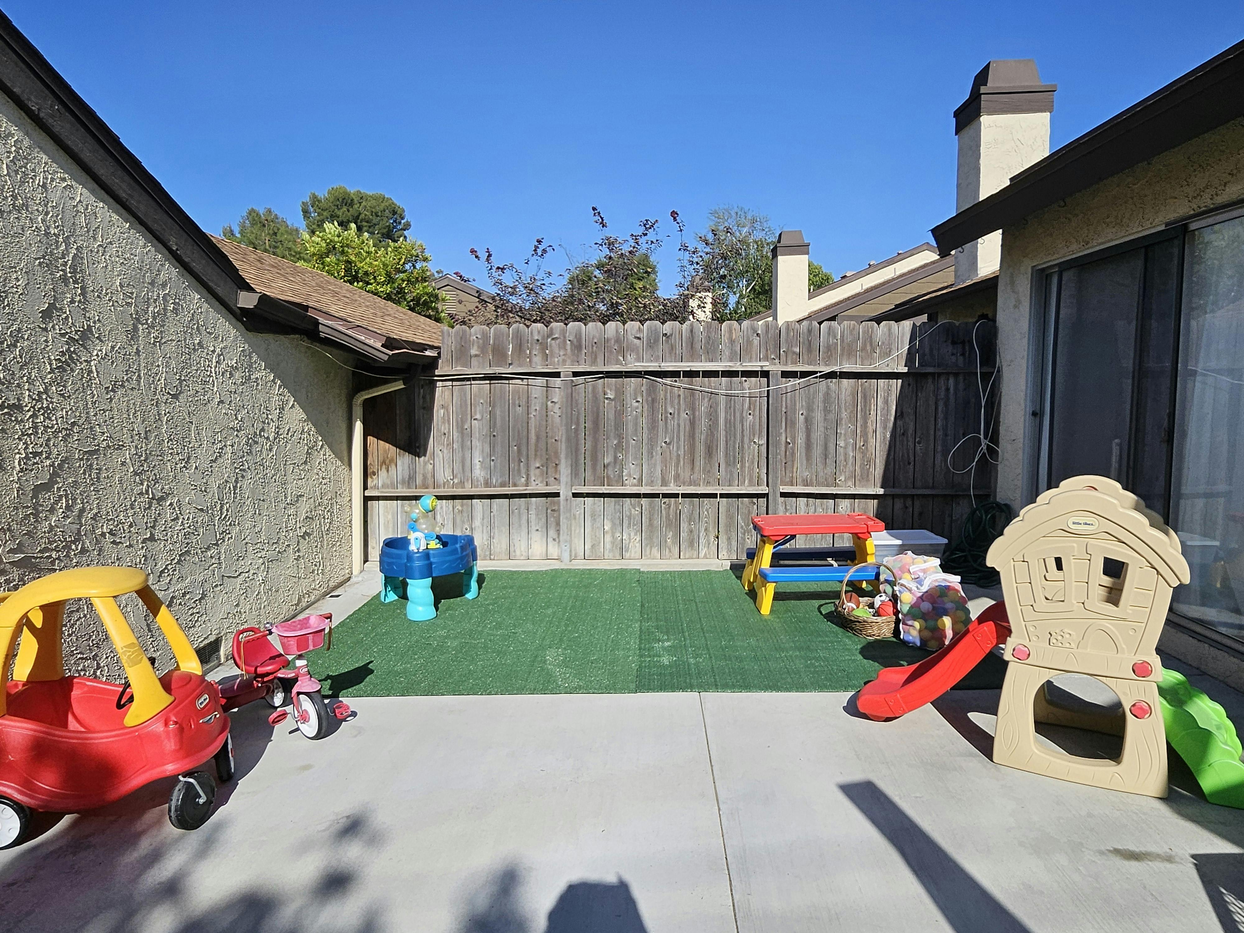 Play area for children with plastic toys on a concrete patio