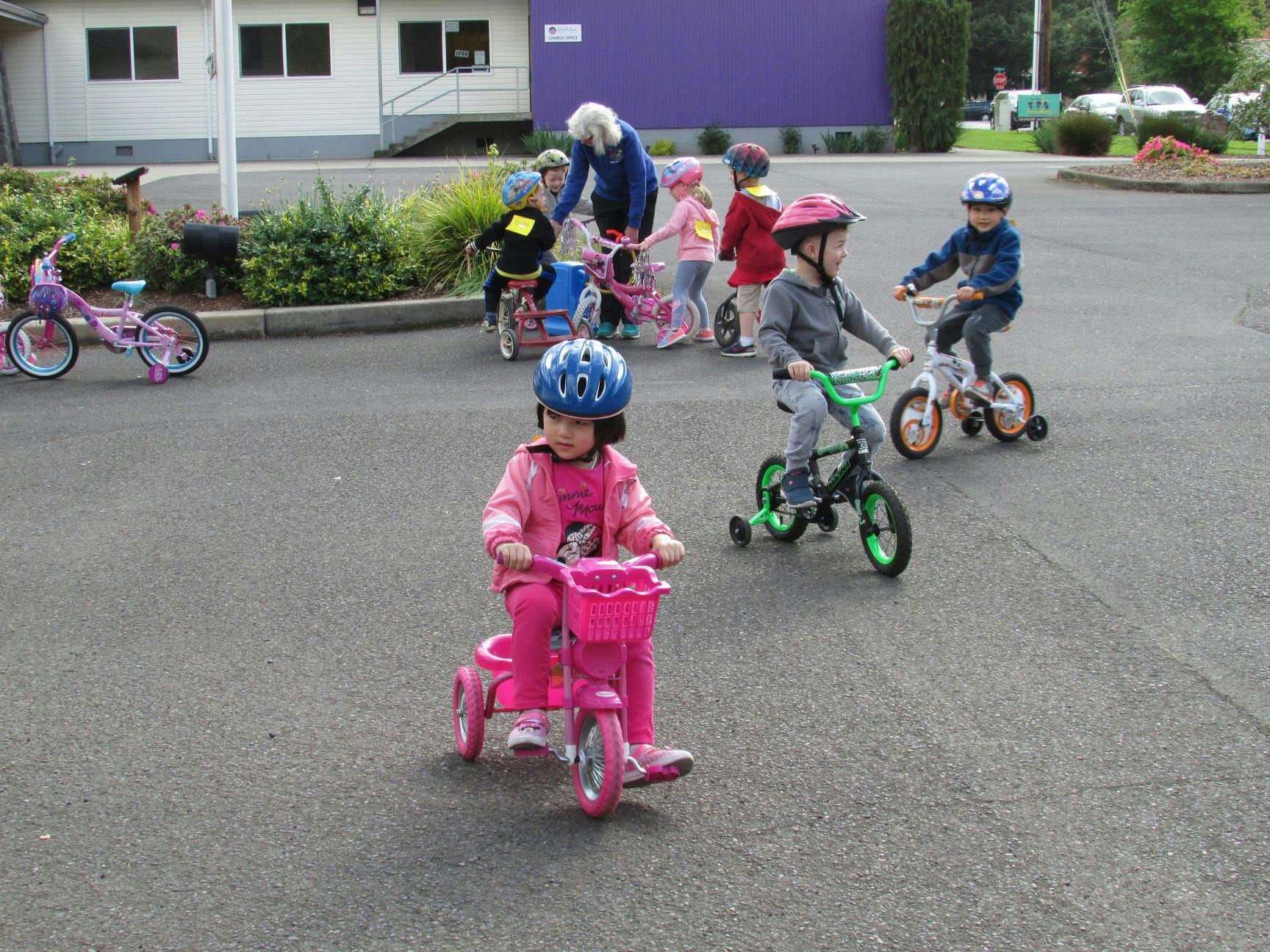 Children riding bicycles and tricycles outdoors