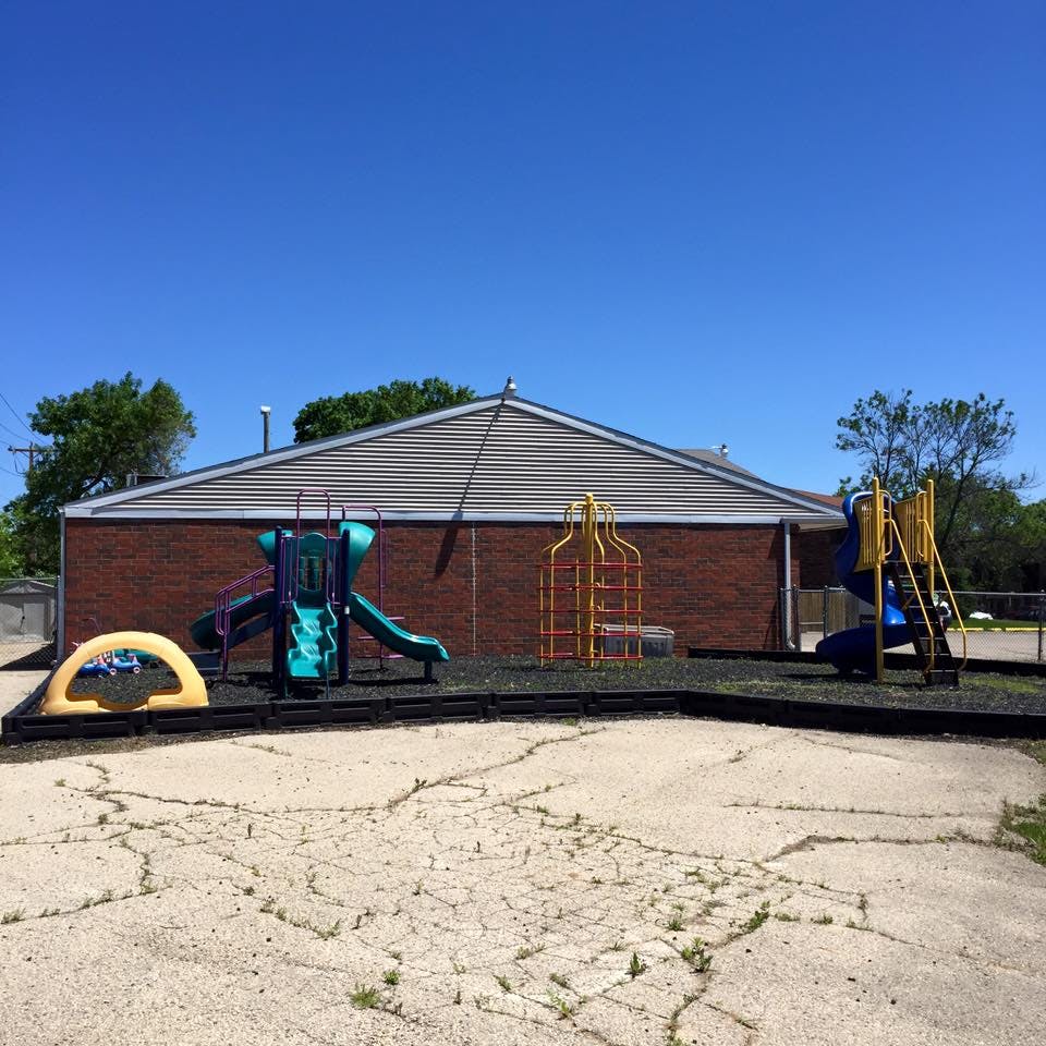 Playground equipment in front of a brick building