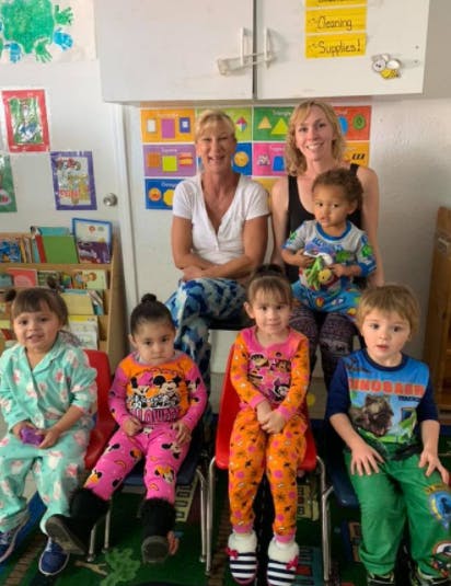 Two women and four children in a classroom