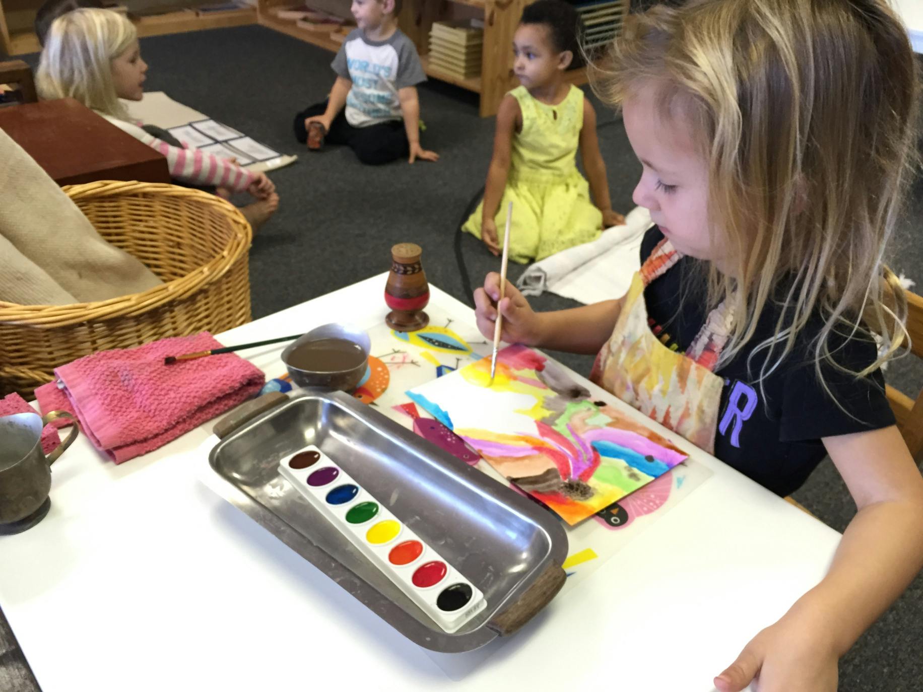 Child painting with watercolors at a table