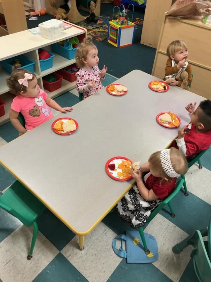 Children sitting at a table with plates of food