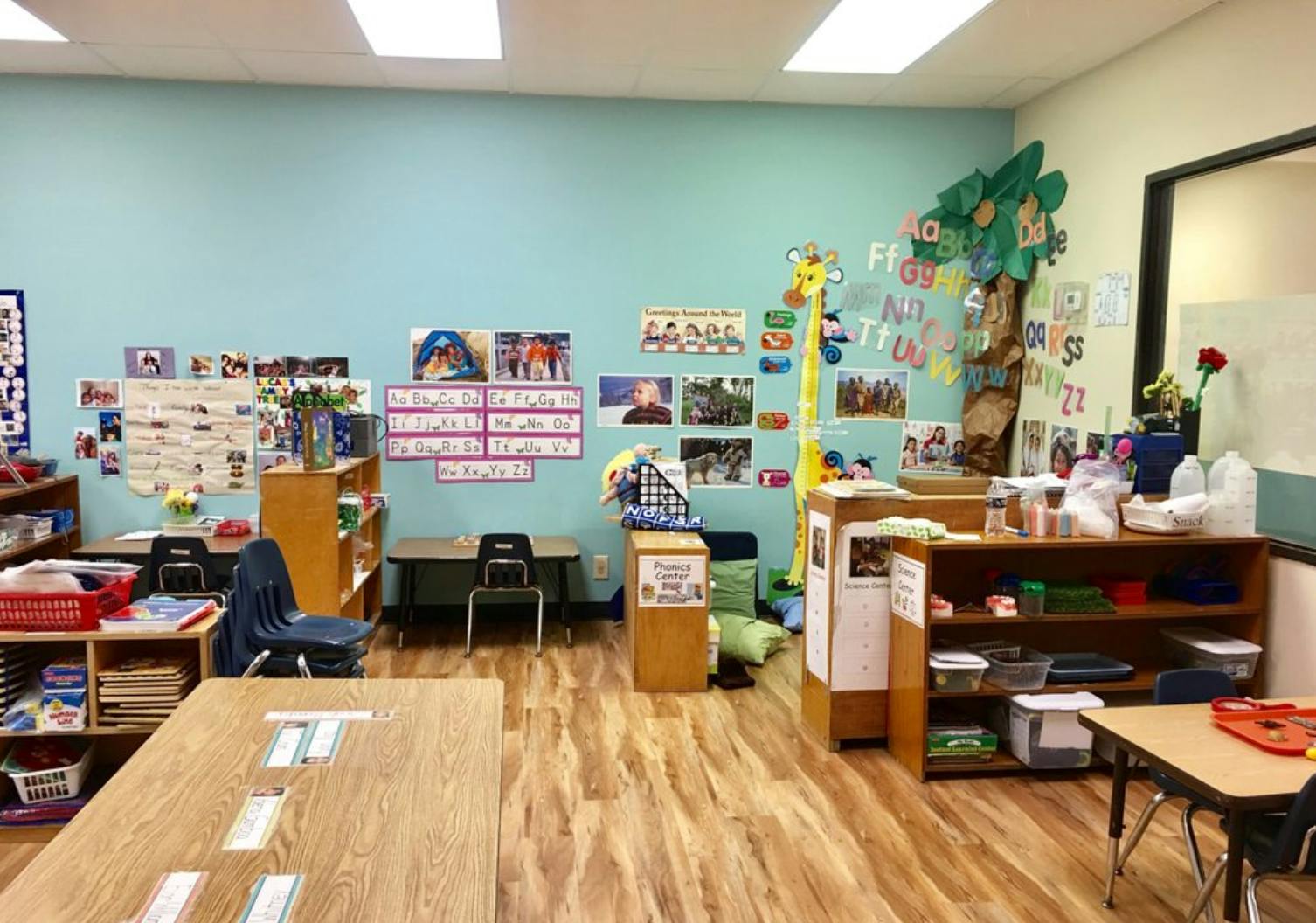 Empty classroom with light blue walls and wooden floors