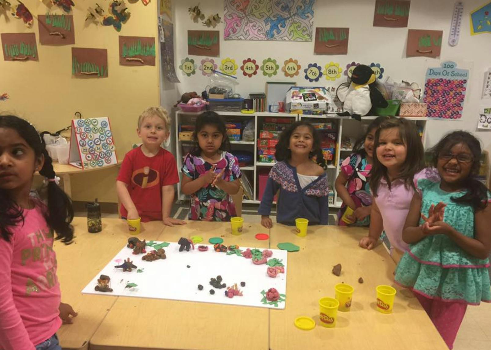 Children standing around a table with playdough creations