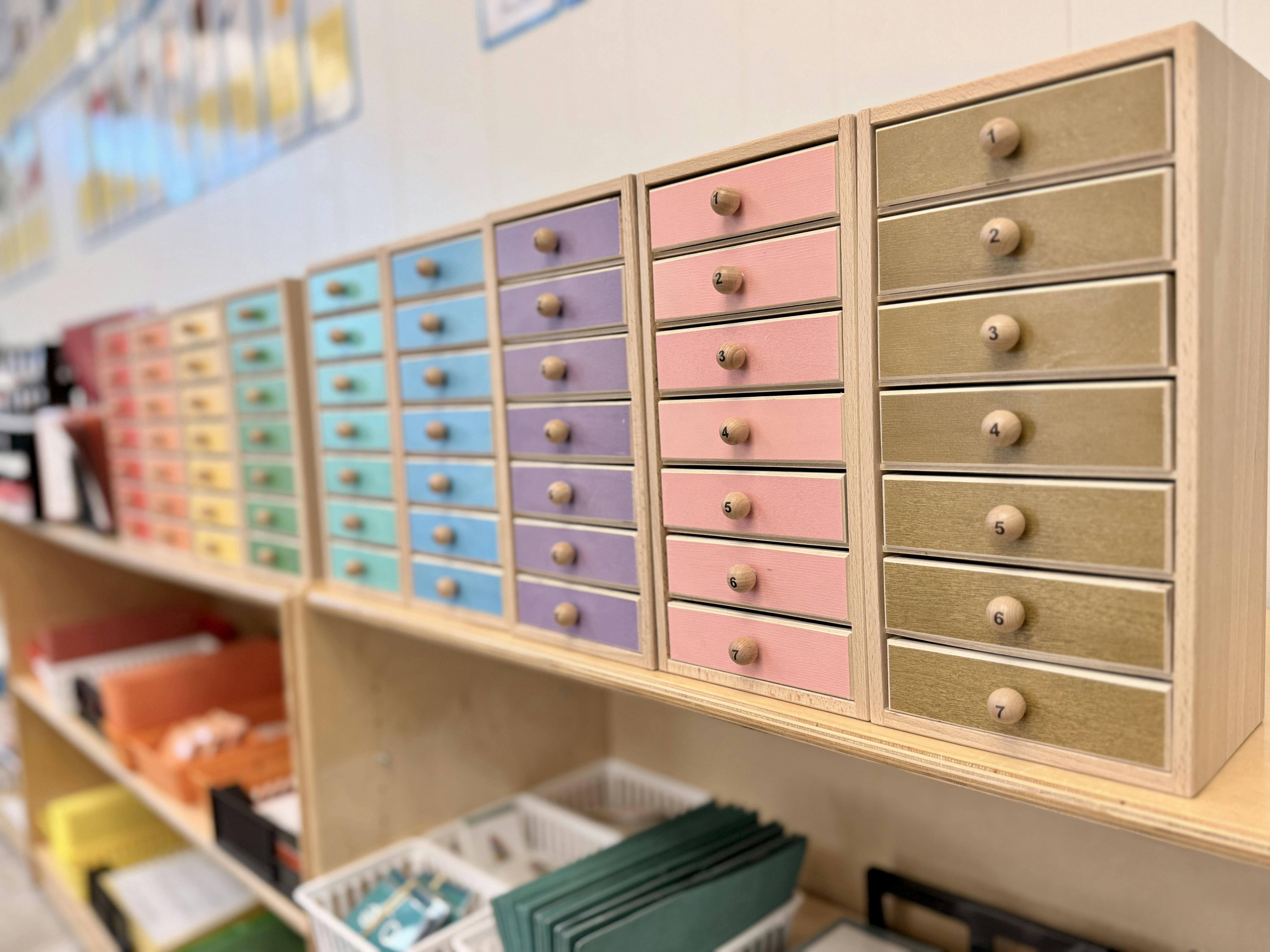 Colorful small drawers with numbered knobs on a wooden shelf