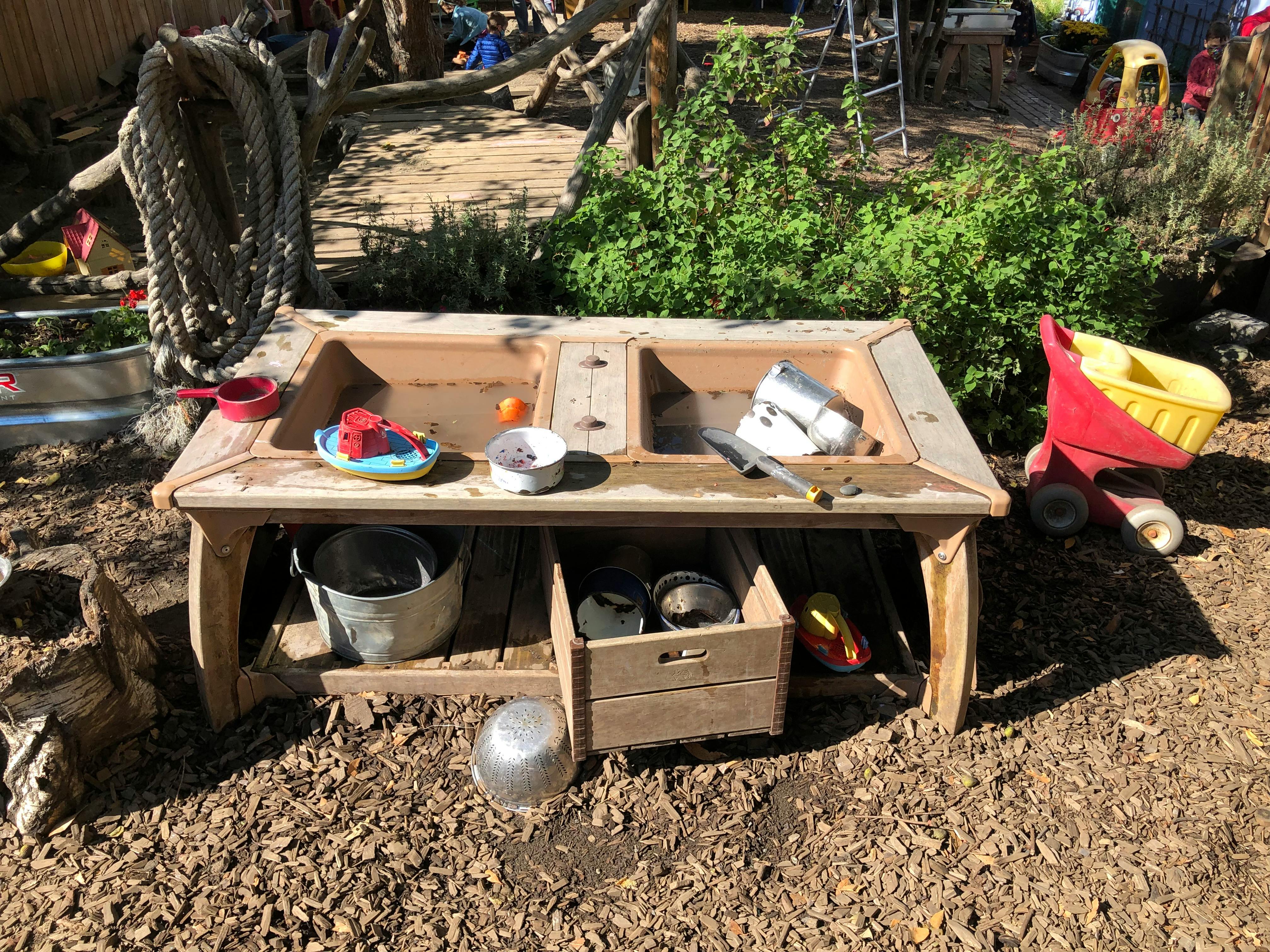 Wooden mud kitchen with various play items