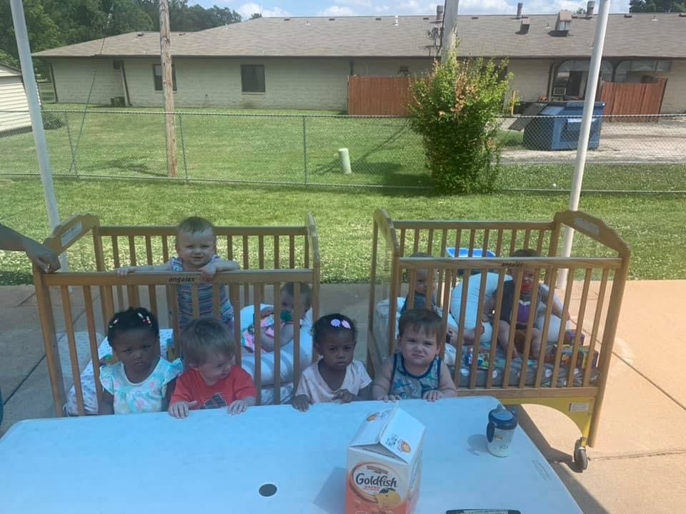 Multiple children in cribs outdoors