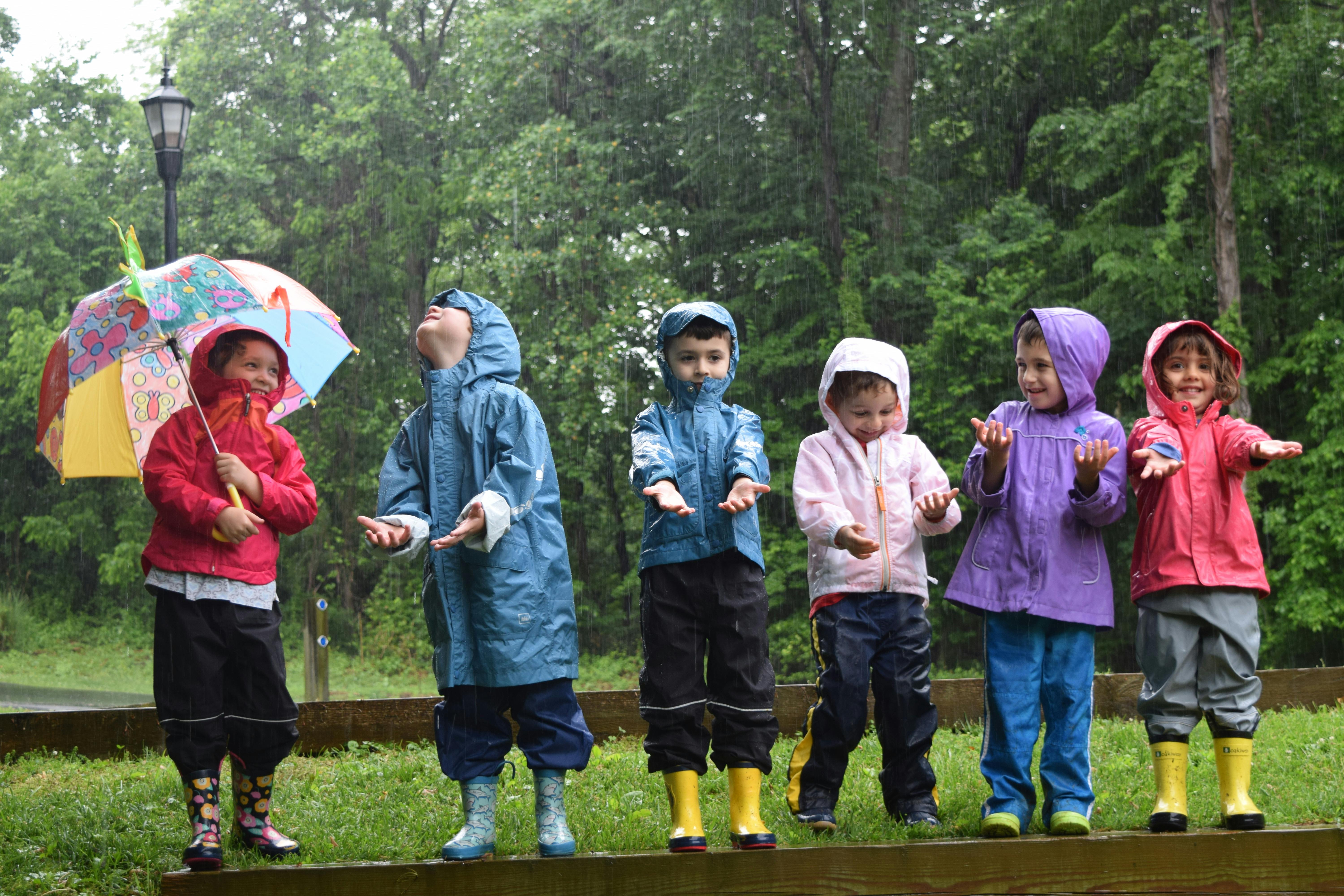Children in rain gear playing in the rain