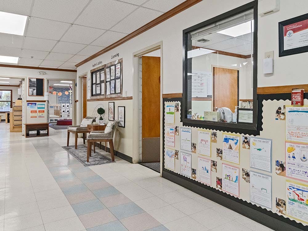 Hallway in an educational facility with bulletin boards and seating area