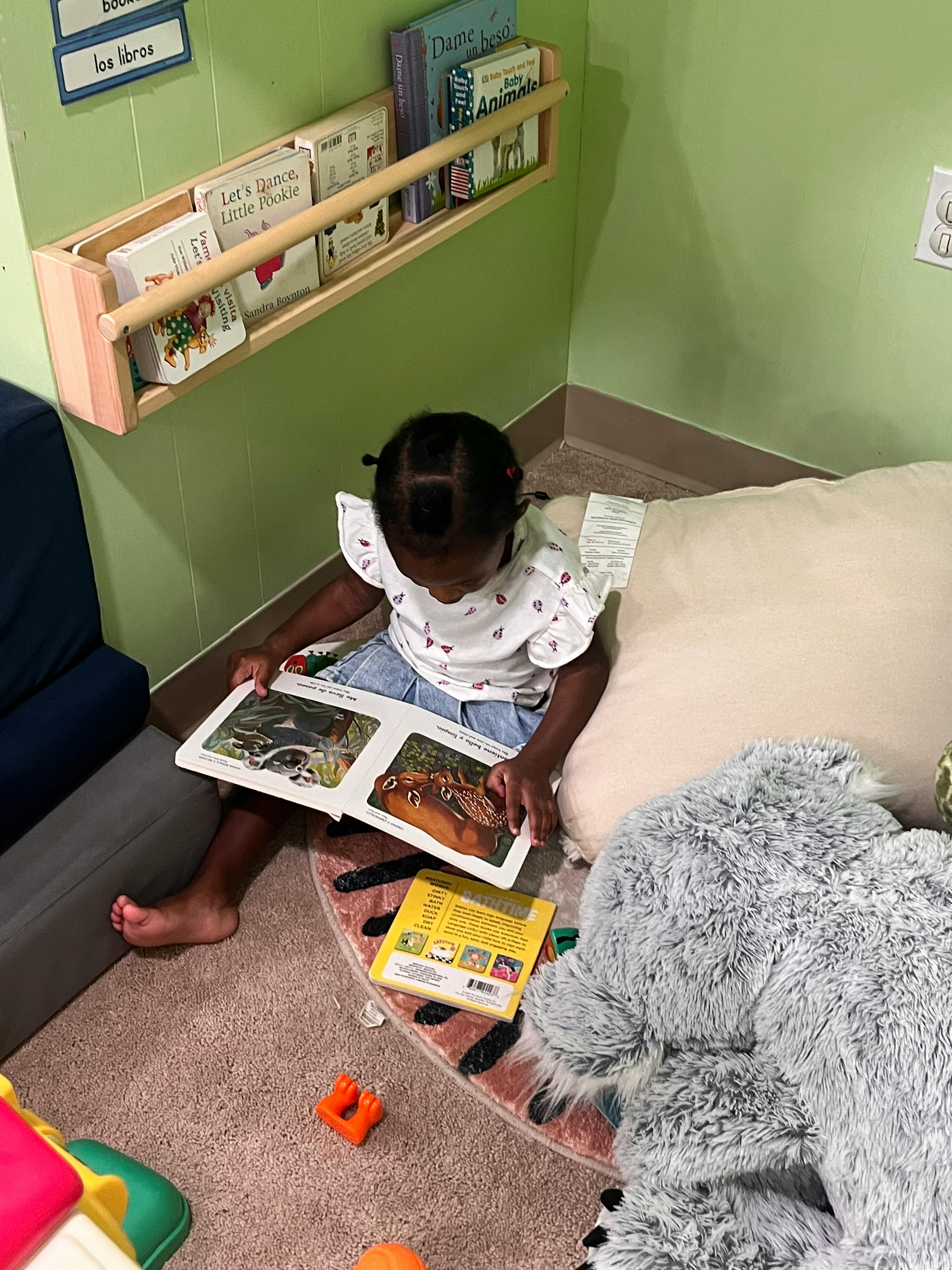 Child sitting on floor reading a book