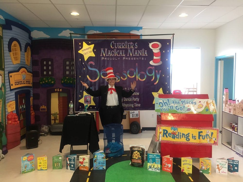 Person in a Cat in the Hat costume standing in front of a banner