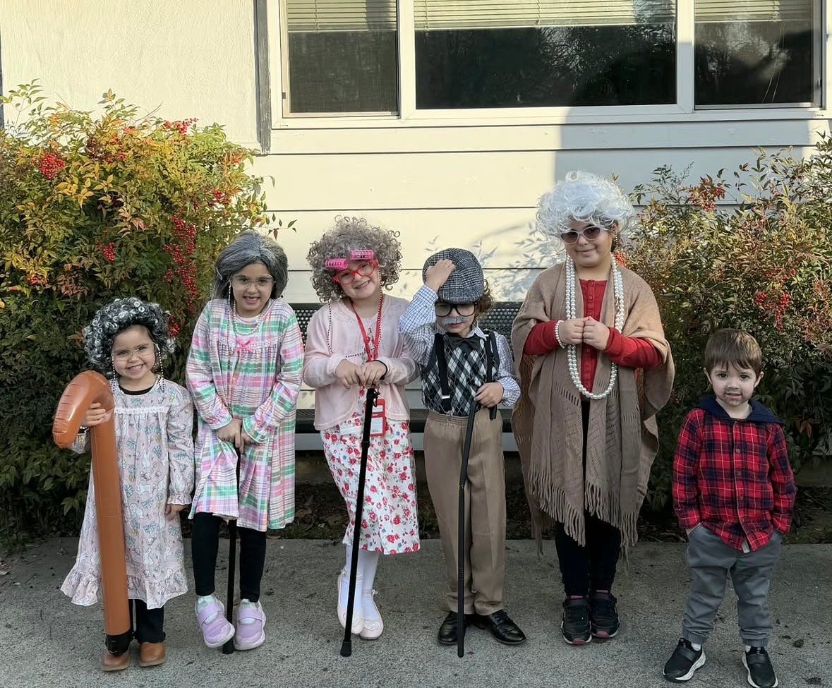 Group of children dressed in costumes resembling elderly people