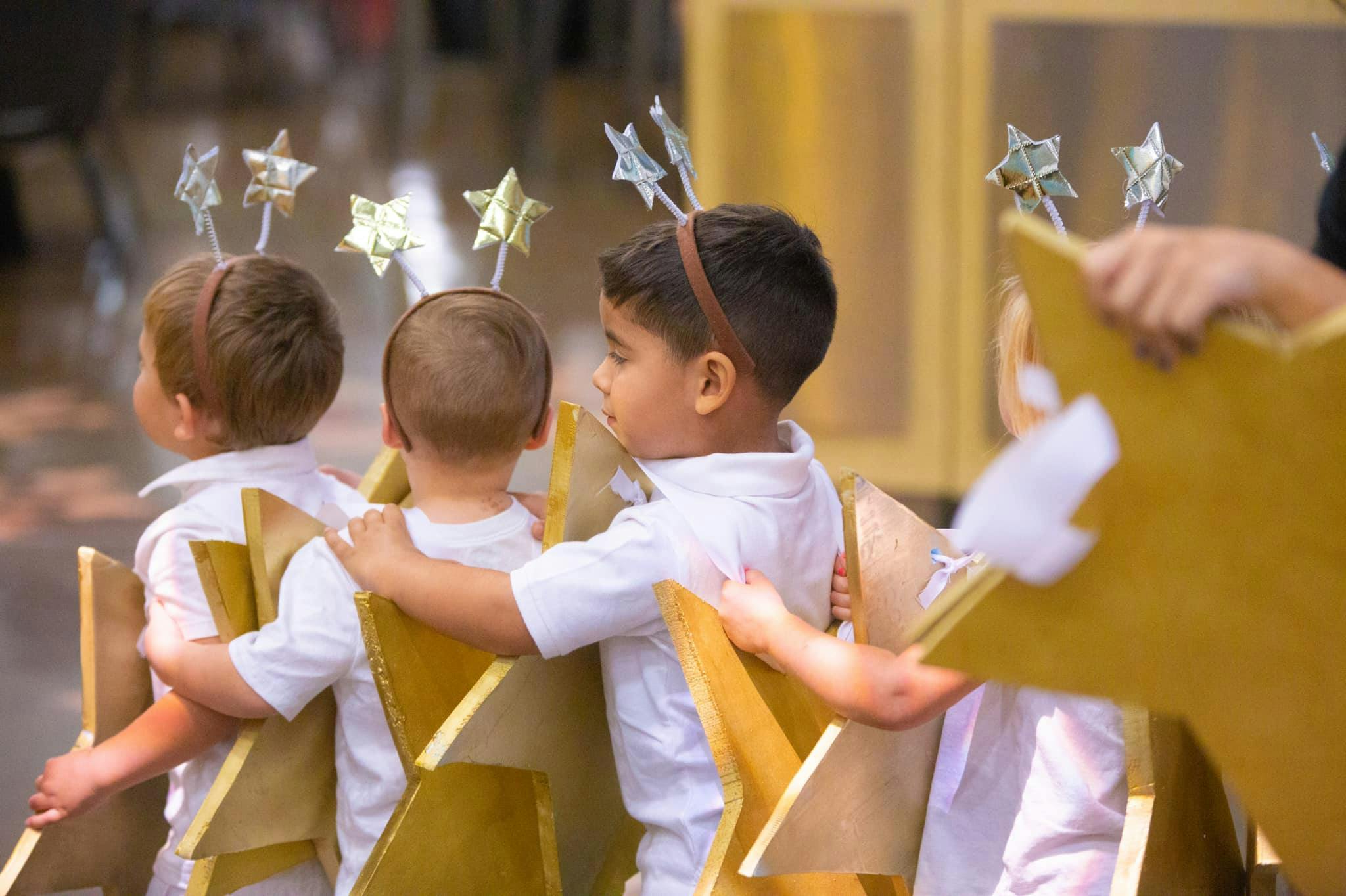 Three children wearing star headbands and star costumes