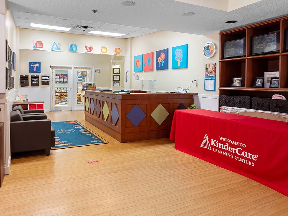 Reception area of a learning center with a red "KinderCare" table covering