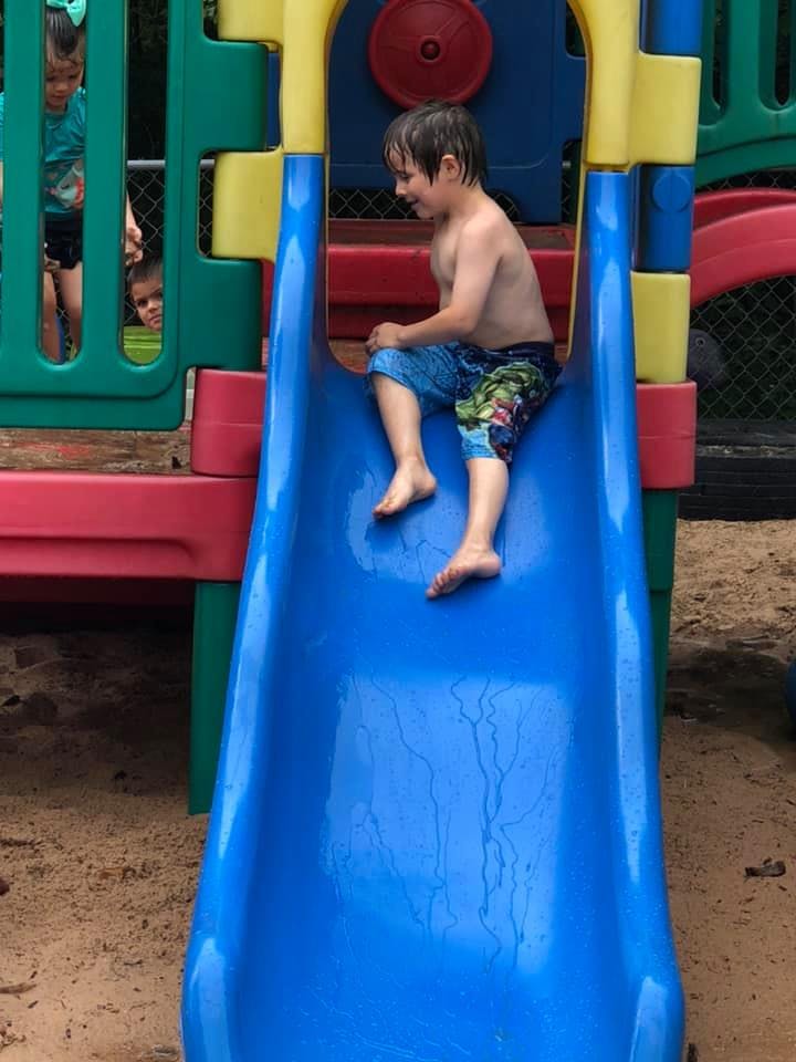 Child on a blue slide at a playground
