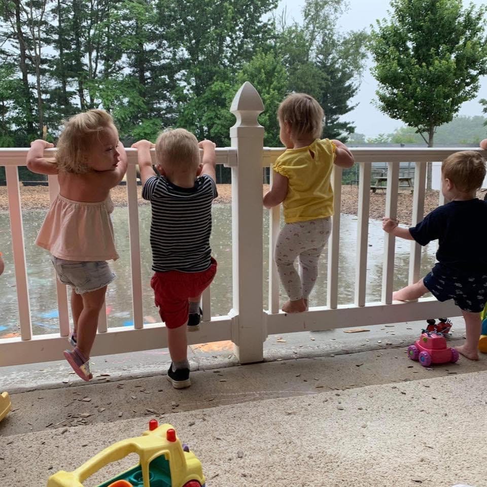 Four children standing at a white railing