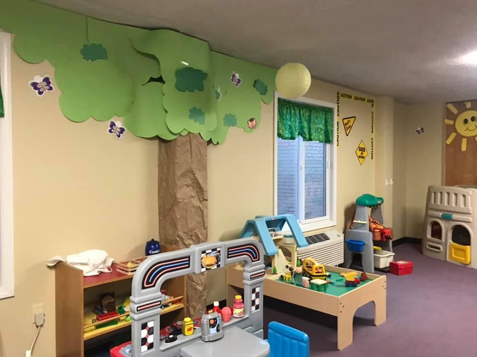 Playroom with toys, a window, and a tree decoration on the wall