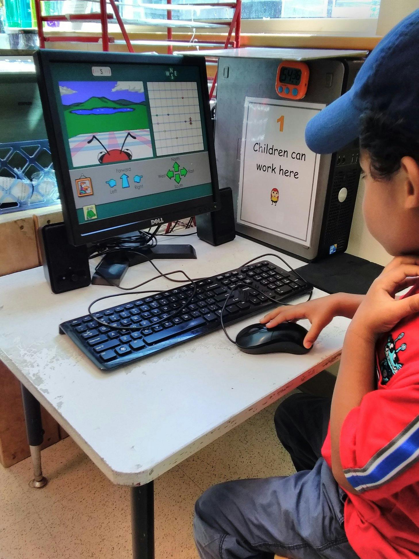 Child using a computer mouse in a classroom