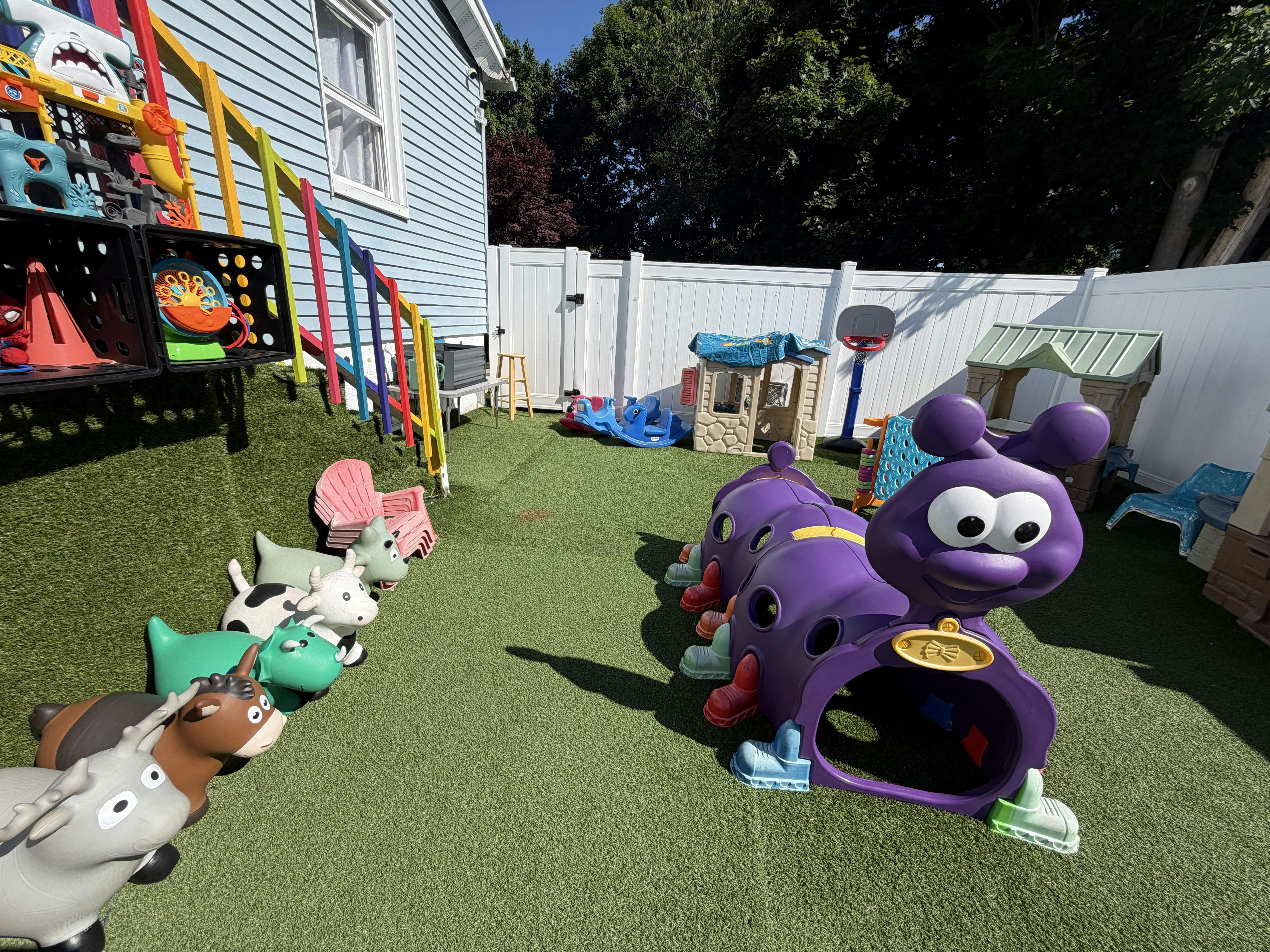 Plastic play equipment including a caterpillar tunnel in a backyard