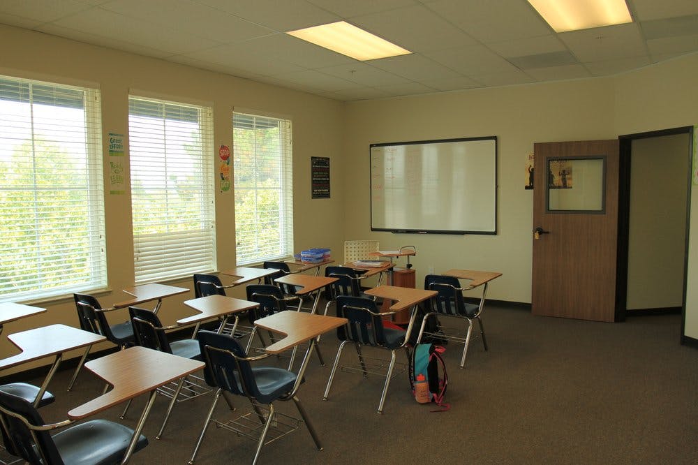 Empty classroom with desks, chairs, and a whiteboard