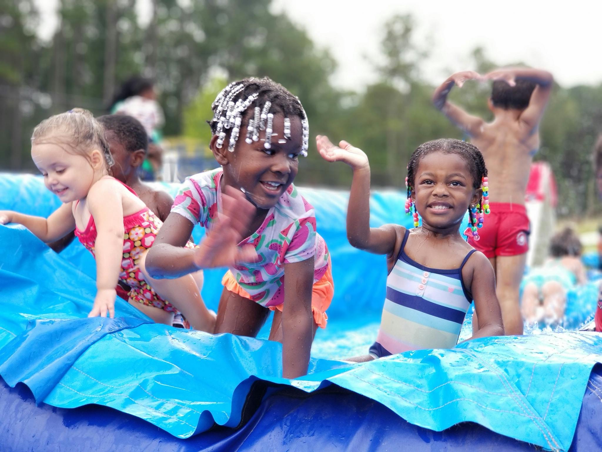 Children playing in a blue inflatable pool