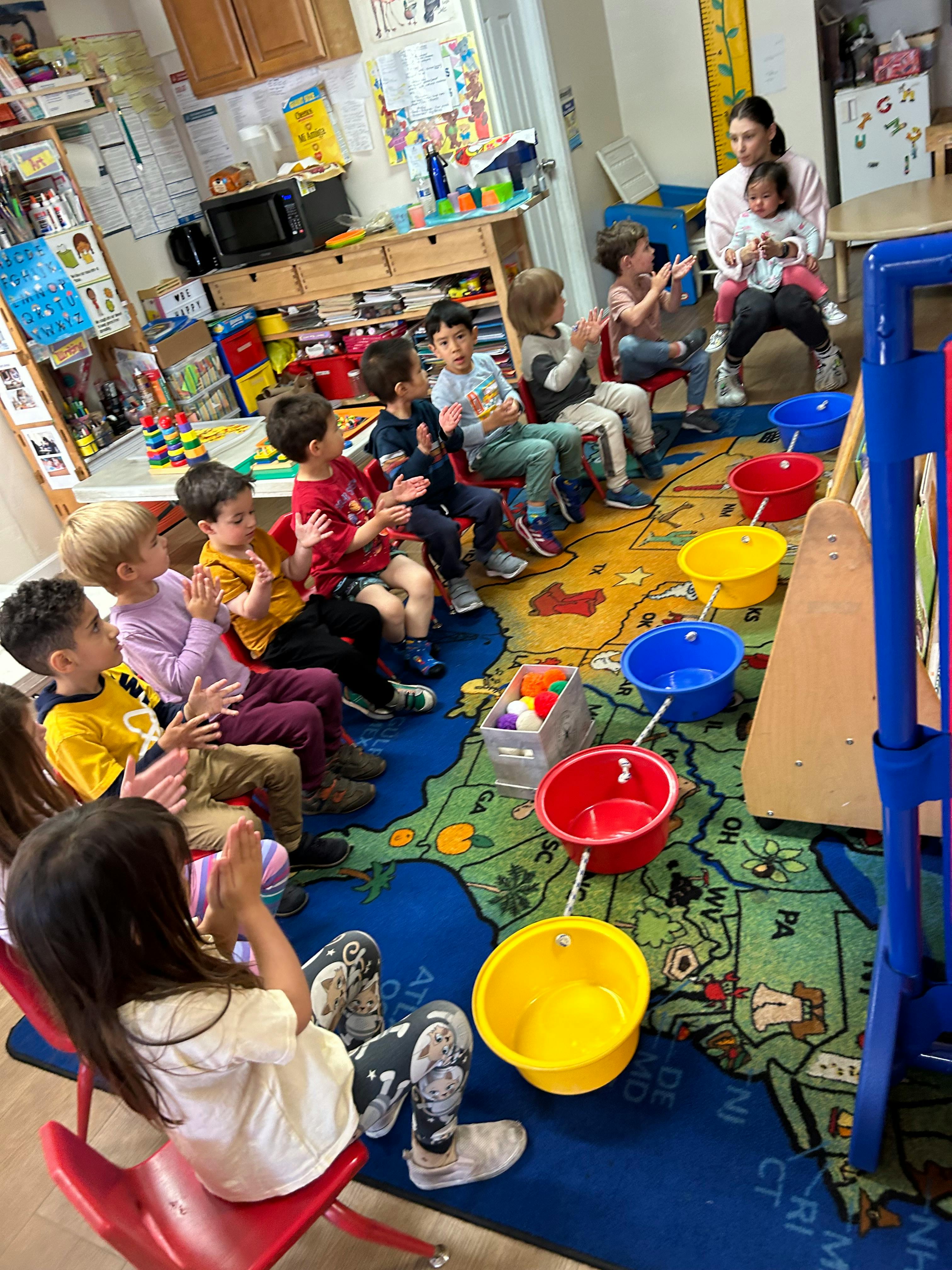 Adult and children sitting on a rug in a classroom