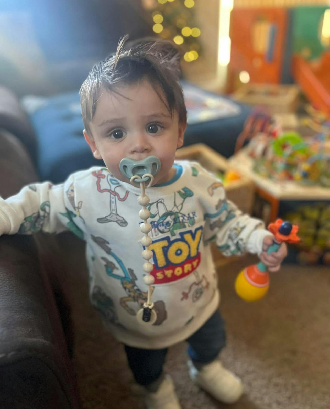 Child with a pacifier and a toy rattle