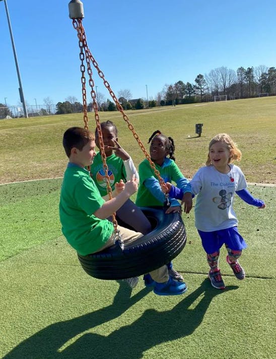 Children playing on a tire swing on a playground