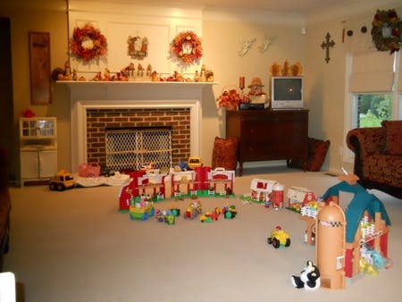 Living room with fireplace and toys scattered on the carpet