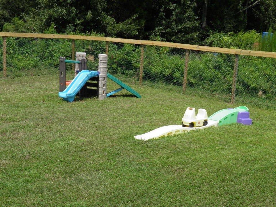 Playground with a blue slide and a toy car on a track
