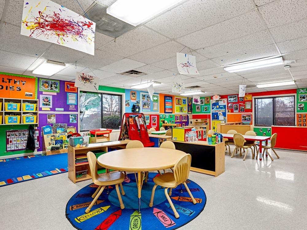 Colorful classroom with children's artwork and small tables