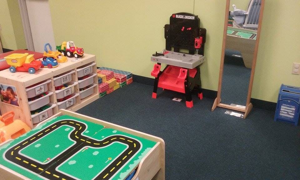 Playroom with toy storage, play table, and child-sized workbench