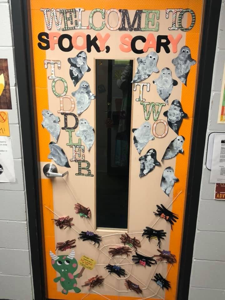 Door decorated with ghosts, spiders, and text "Welcome to Spooky, Scary, Old, Two"