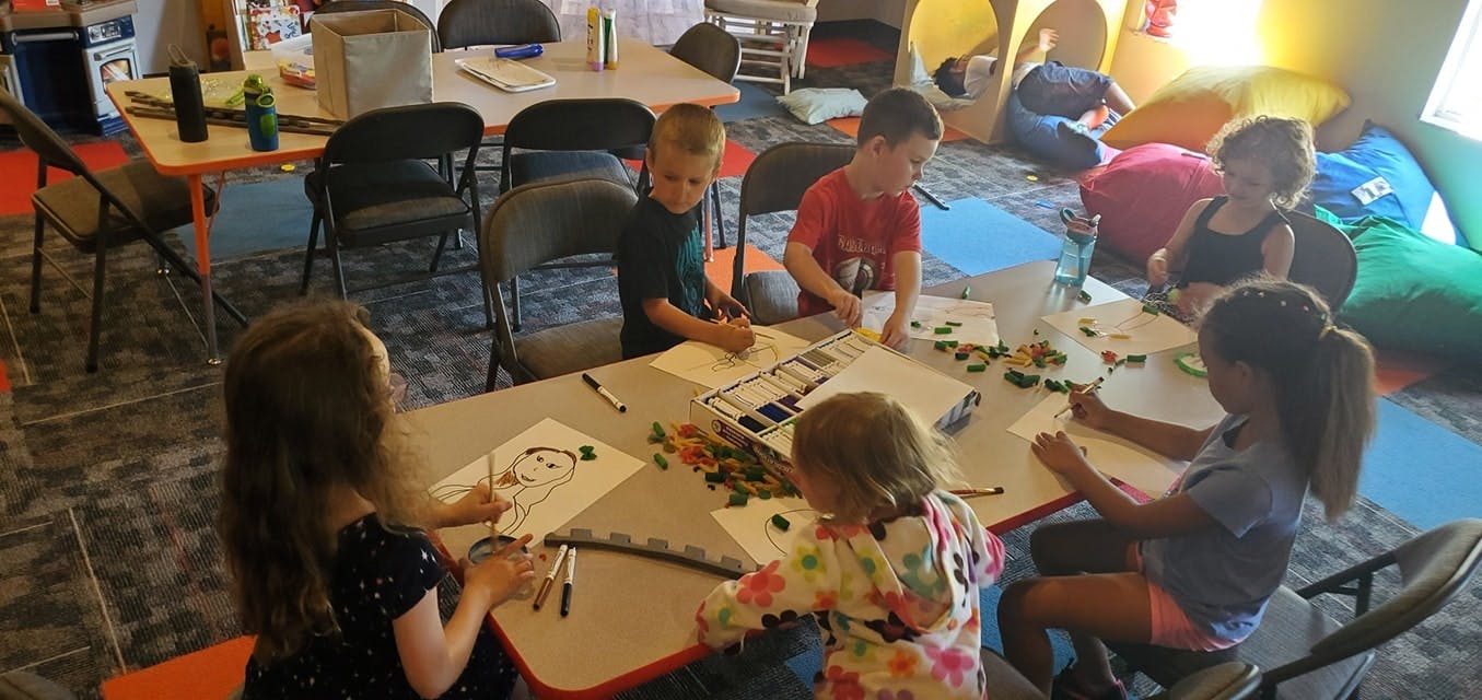 Children drawing and painting at a table