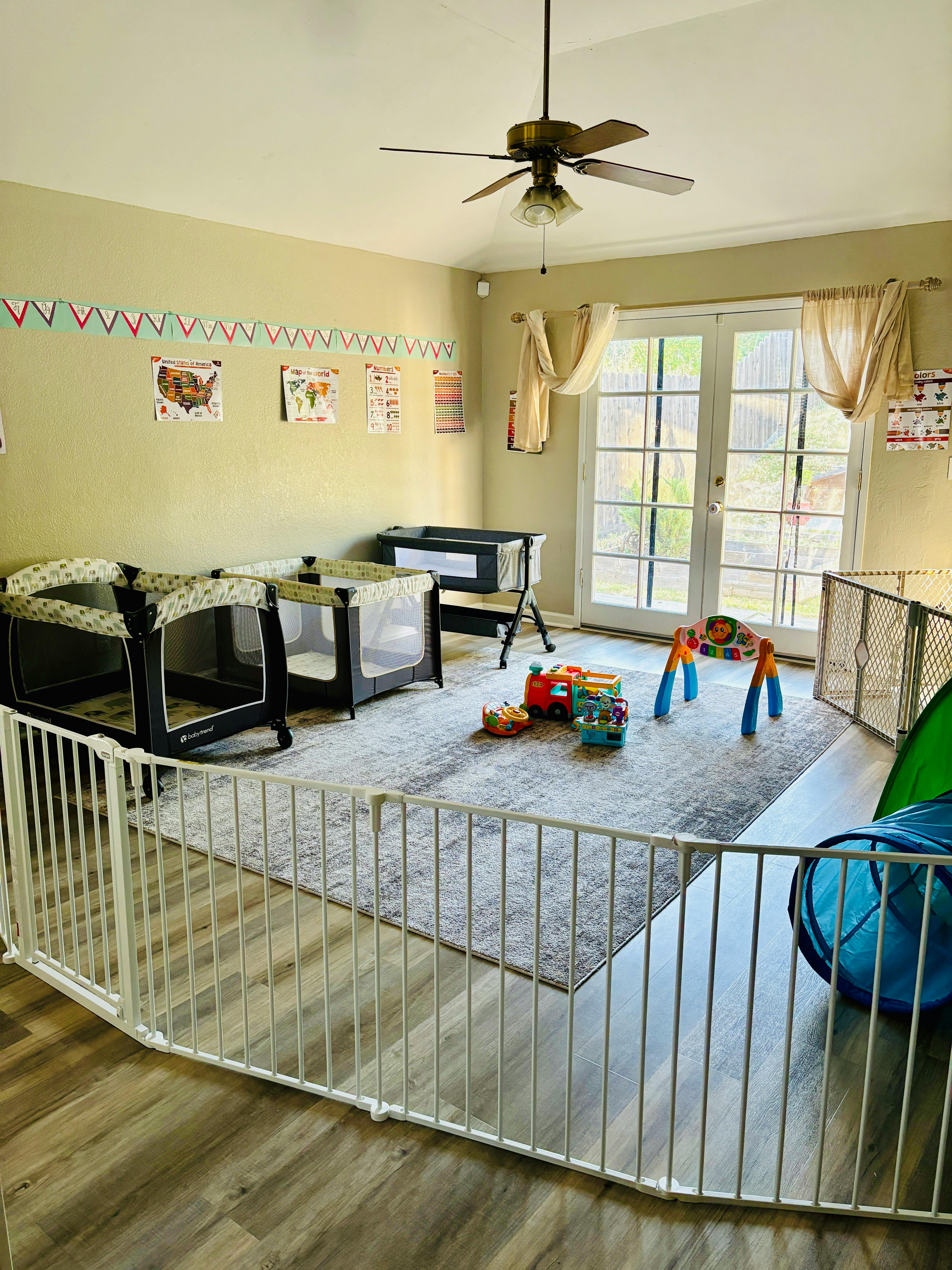 Playroom with cribs, playpen, and toys on a rug