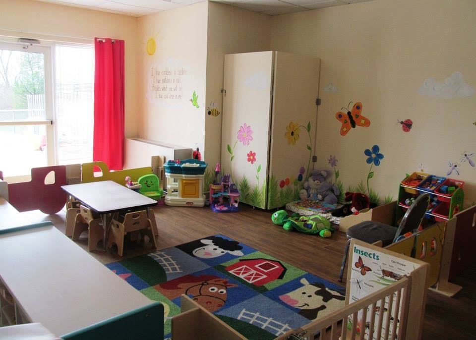 Playroom with a colorful rug, small tables, and toys