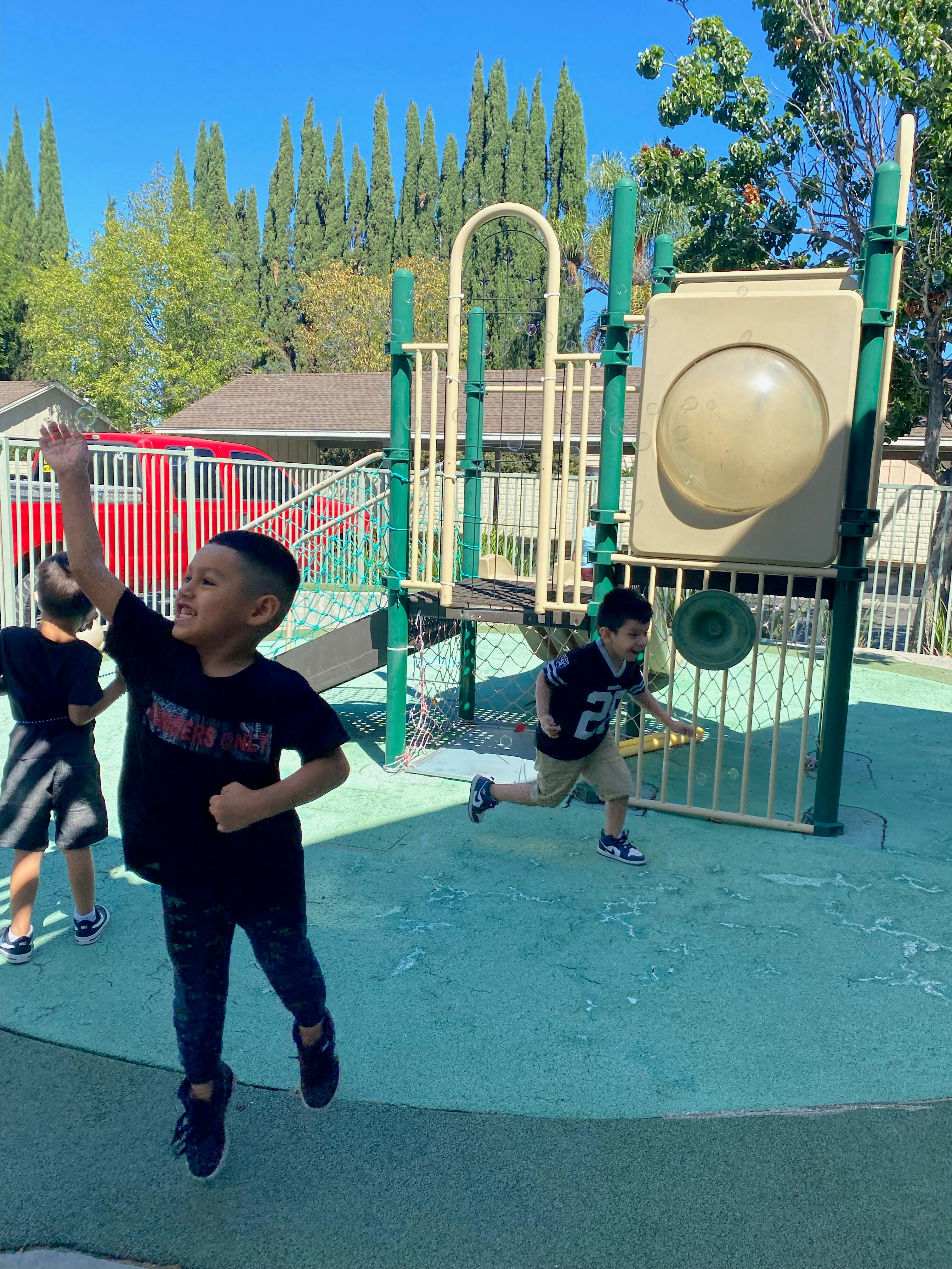 Children playing with soap bubbles at a playground