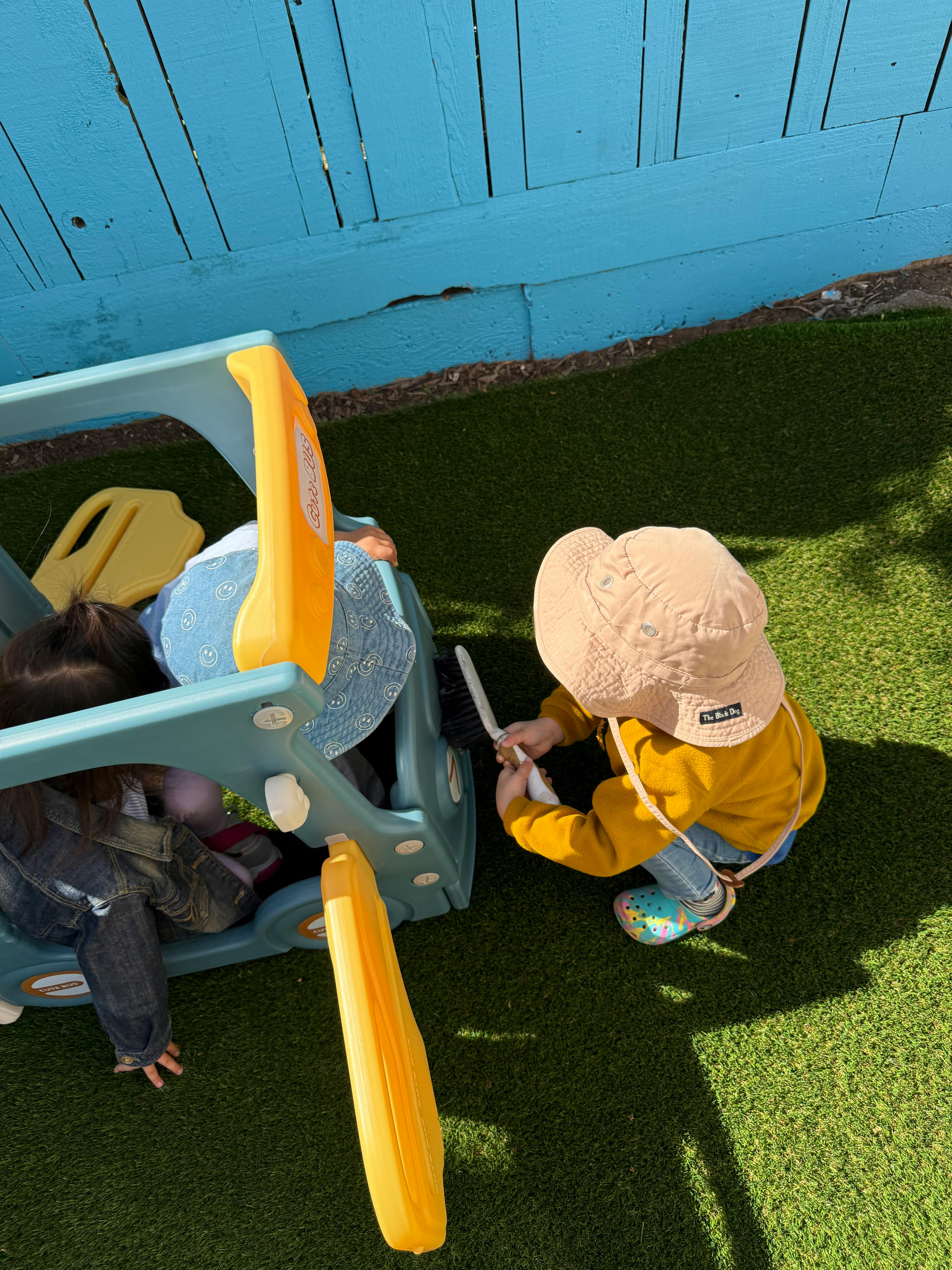 Child playing with a toy on artificial grass