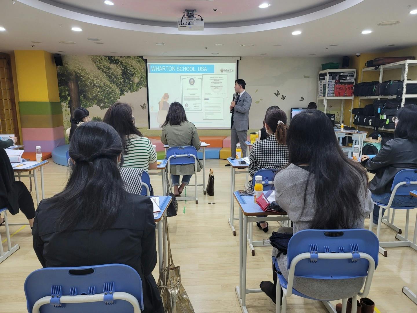 Person presenting to a group of people in a classroom setting