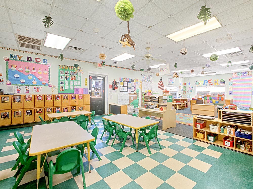 Classroom with small tables and chairs, cubbies, and colorful decorations
